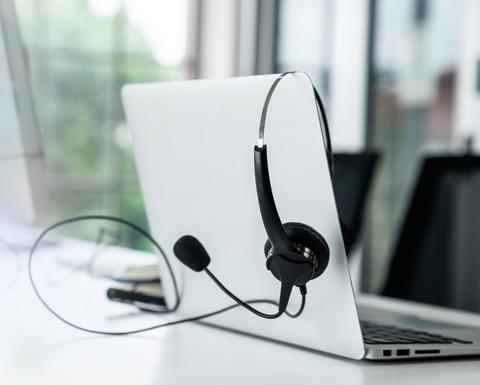 laptop with headphones hanging on screen